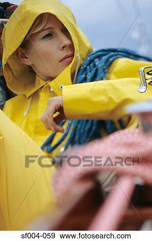 Woman in yellow raincoat carrying rope View Large Photo Image Stock Photo - Woman in yellow raincoat carrying rope. Fotosearch