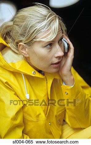 Woman in yellow raincoat using mobile phone View Large Photo Image Stock Photography - Woman in yellow raincoat using mobile phone. Fotosearch