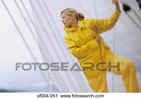 Woman on boat in yellow waterproofs holding rope View Large Photo Image Stock Image - Woman on boat in yellow waterproofs holding rope. Fotosearch
