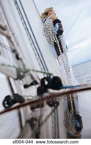 Woman standing on boat carrying rope on her shoulder View Large Photo Image Picture - Woman standing on boat carrying rope on her shoulder. Fotosearch