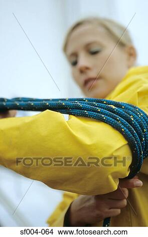 Picture - Woman winding rope around her arm. Fotosearch