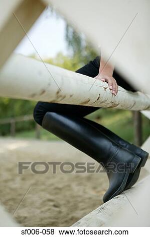 Horse rider sitting on a fence View Large Photo Image Stock Photo - Horse rider sitting on a fence. Fotosearch
