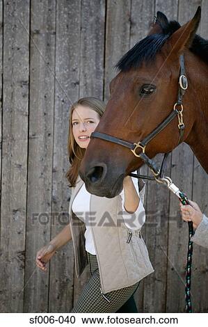 Stock Image - Young woman leading a horse. Fotosearch