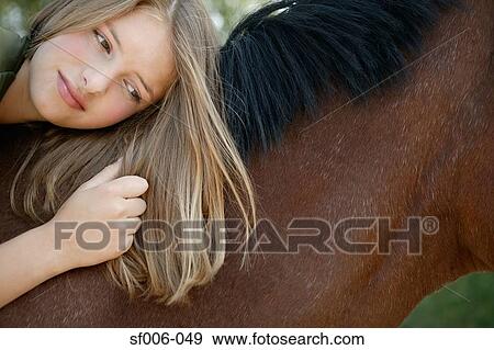 Young woman lying on her horse View Large Photo Image Stock Photo - Young woman lying on her horse. Fotosearch