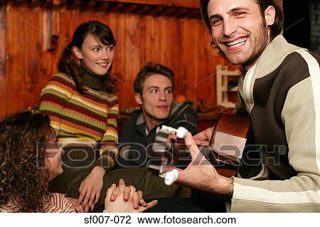 Man playing guitar to his friends View Large Photo Image Stock Image - Man playing guitar to his friends. Fotosearch
