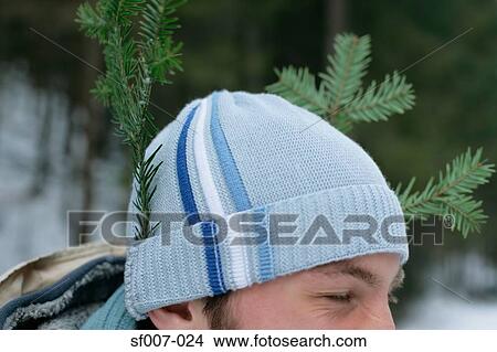 Picture - Man with pieces of tree in his hat. Fotosearch