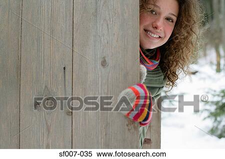 Woman hiding behind a fence View Large Photo Image Stock Photography - Woman hiding behind a fence. Fotosearch