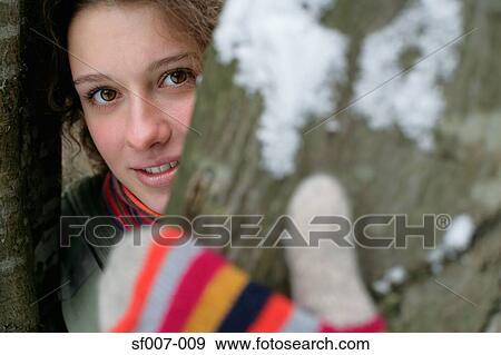 Woman in gloves behind a tree View Large Photo Image Stock Photo - Woman in gloves behind a tree. Fotosearch