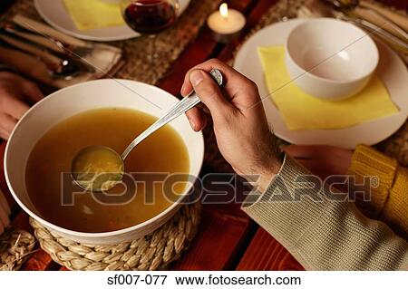Young man serving soup View Large Photo Image Stock Photo - Young man serving soup. Fotosearch