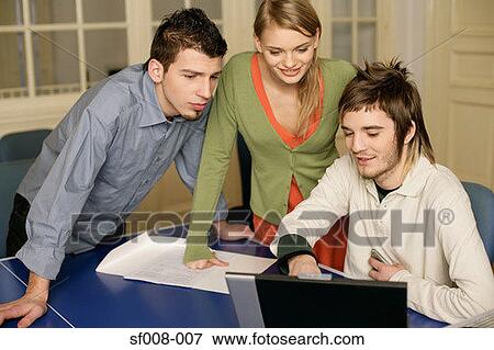Colleagues looking at computer View Large Photo Image Stock Photo - Colleagues looking at computer. Fotosearch