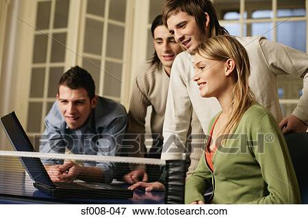 Stock Photo - Colleagues looking at laptop. Fotosearch