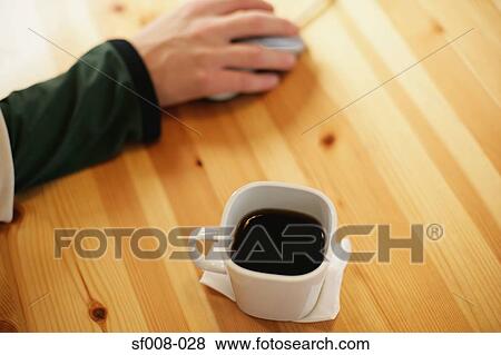 Hand on computer mouse with coffee cup View Large Photo Image Stock Photo - Hand on computer mouse with coffee cup. Fotosearch