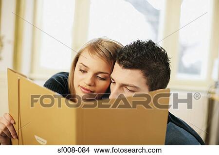 Man and woman looking at folder View Large Photo Image Picture - Man and woman looking at folder. Fotosearch