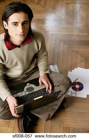 Man sitting on the floor with laptop View Large Photo Image Stock Photo - Man sitting on the floor with laptop. Fotosearch