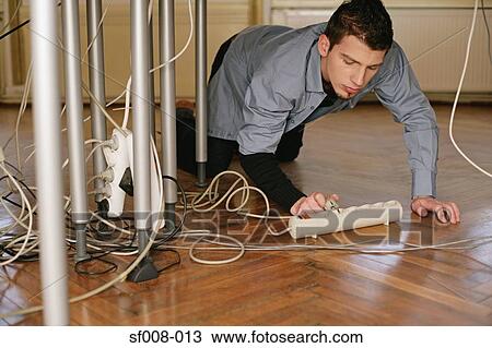 Stock Image - Man with plug and cables. Fotosearch