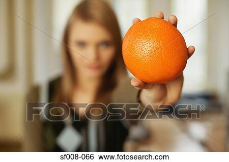 Woman holding out an orange View Large Photo Image Stock Photograph - Woman holding out an orange. Fotosearch