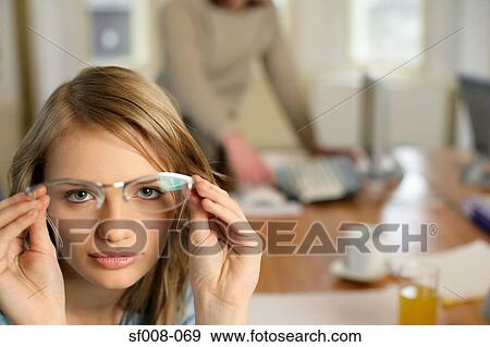 Woman holding up a pair of glasses View Large Photo Image Stock Photo - Woman holding up a pair of glasses. Fotosearch