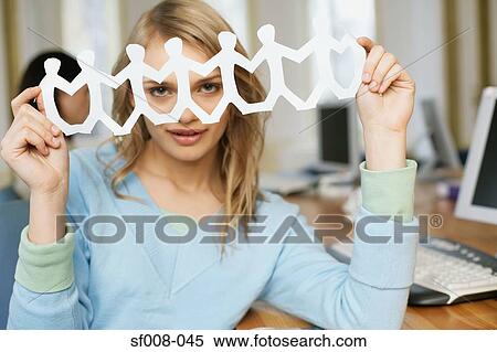 Stock Photography - Woman holding up paper chain. Fotosearch