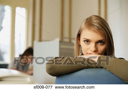 Woman leaning on the back of her chair View Large Photo Image Stock Photo - Woman leaning on the back of her chair. Fotosearch