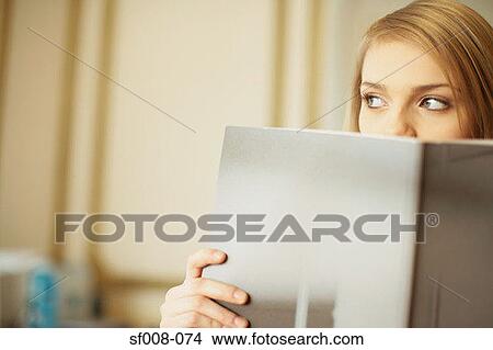 Woman peering over top of folder View Large Photo Image Picture - Woman peering over top of folder. Fotosearch