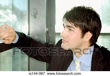 Stock Photo - Businessman leaning against window. Fotosearch