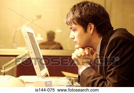 Stock Photography - Businessman staring at computer monitor. Fotosearch