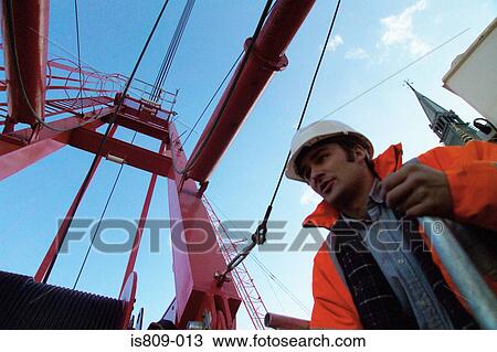 Construction worker by red crane View Large Photo Image Stock Image - Construction worker by red crane. Fotosearch