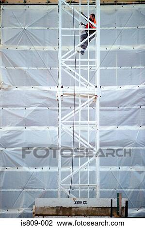 Construction worker climbing up a metal tower View Large Photo Image Stock Image - Construction worker climbing up a metal tower . Fotosearch