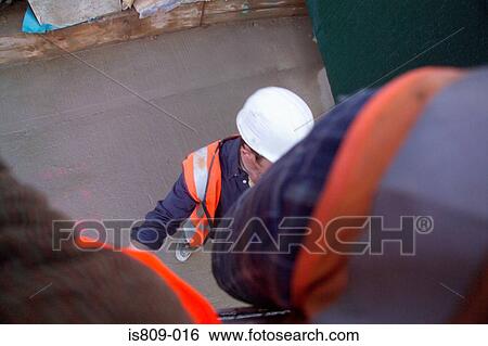 Construction workers at a building site View Large Photo Image Stock Photograph - Construction workers at a building site. Fotosearch