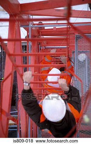 Construction workers climbing up a metal tower View Large Photo Image Stock Photo - Construction workers climbing up a metal tower . Fotosearch
