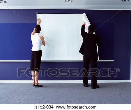 Picture - Businesspeople attaching chart to wall. Fotosearch
