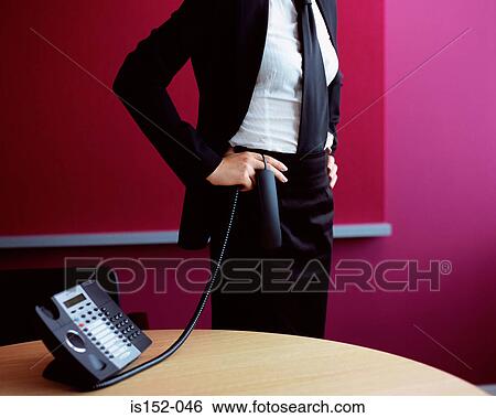 Stock Photograph - Businesswoman holding a telephone handset. Fotosearch