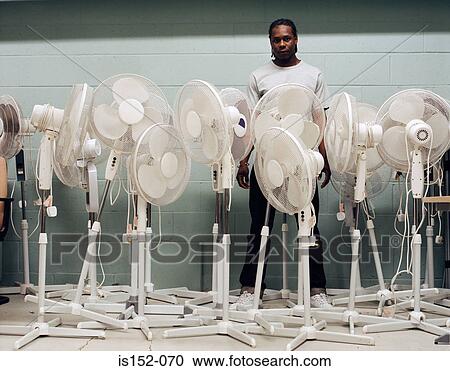 Stock Image - Man trapped by electric fans. Fotosearch