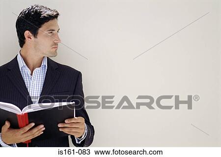 Stock Image - Businessman holding a notebook. Fotosearch