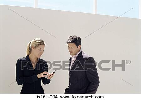 Businesswoman showing businessman her phone View Large Photo Image Picture - Businesswoman showing businessman her phone. Fotosearch