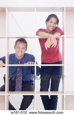 Colleagues leaning on shelves View Large Photo Image Stock Image - Colleagues leaning on shelves. Fotosearch