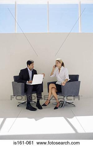 Colleagues using mobile and laptop View Large Photo Image Stock Image - Colleagues using mobile and laptop. Fotosearch