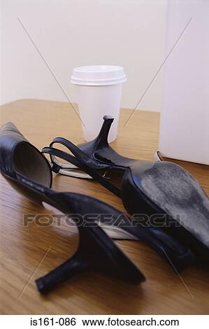 High heeled shoes and cup on a desk View Large Photo Image Stock Photograph - High heeled shoes and cup on a desk. Fotosearch