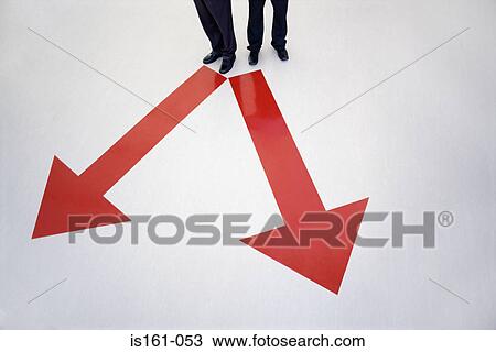 Men standing between direction arrows View Large Photo Image Stock Image - Men standing between direction arrows. Fotosearch
