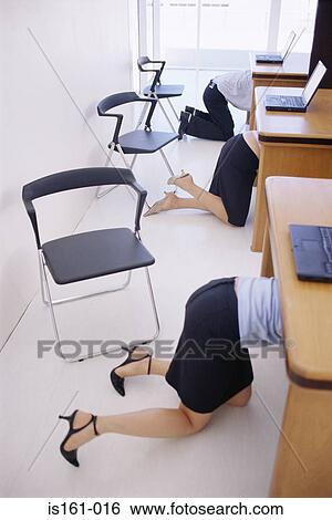 Stock Photograph - Office workers crawling under their desks. Fotosearch