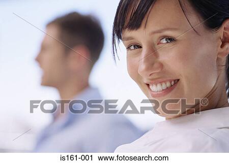 Stock Image - Smiling woman with colleague. Fotosearch