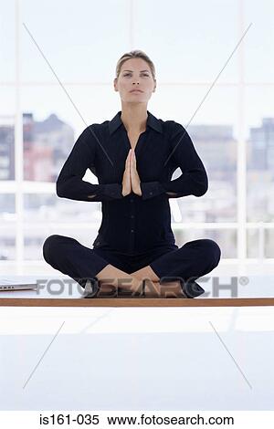 Woman meditating on her desk View Large Photo Image Stock Photography - Woman meditating on her desk. Fotosearch