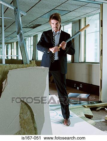 Stock Image - Businessman holding baseball bat. Fotosearch