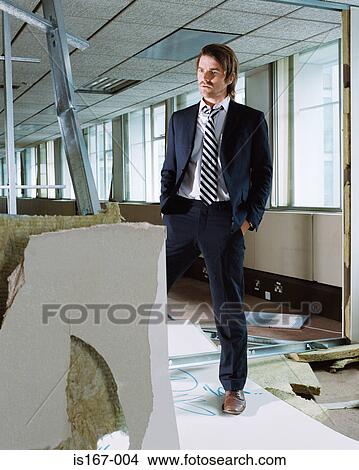 Businessman in a vandalised office View Large Photo Image Picture - Businessman in a vandalised office. Fotosearch