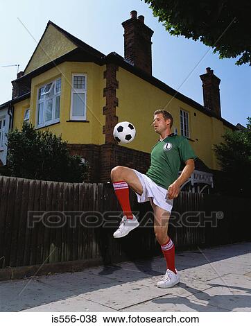 Footballer playing on pavement View Large Photo Image Stock Photo - Footballer playing on pavement. Fotosearch