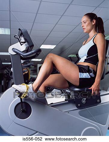 Woman using an exercise bike View Large Photo Image Stock Image - Woman using an exercise bike. Fotosearch
