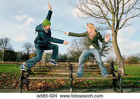 Couple playing on park bench View Large Photo Image Picture - Couple playing on park bench. Fotosearch