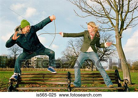 Couple playing on park bench View Large Photo Image Stock Photography - Couple playing on park bench. Fotosearch