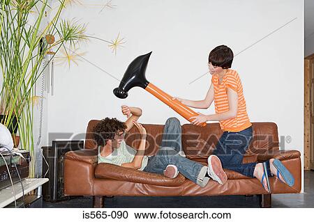 Stock Image - Couple playing with inflatable hammer. Fotosearch