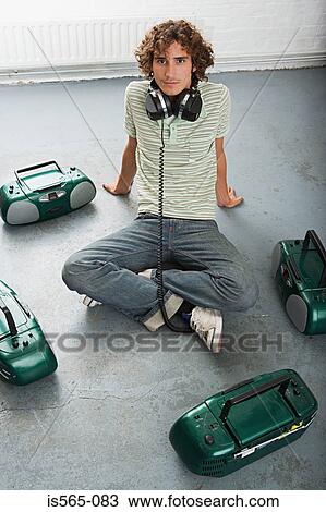 Stock Image - Man listening to four stereos. Fotosearch